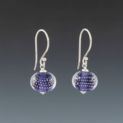 Ink Blue Sparkling Earrings (Ear Wires) by Becky Congdon are handmade glass beads of ink blue (light purple blue) glass with small silver balls encased with clear glass. The beads dangle from silver Bali ear wires with tiny silver saucers on either side of the bead.