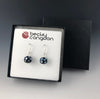 The handmade cobalt blue mirrored dot earrings are displayed on a earring card in a black pinstripe gift box.