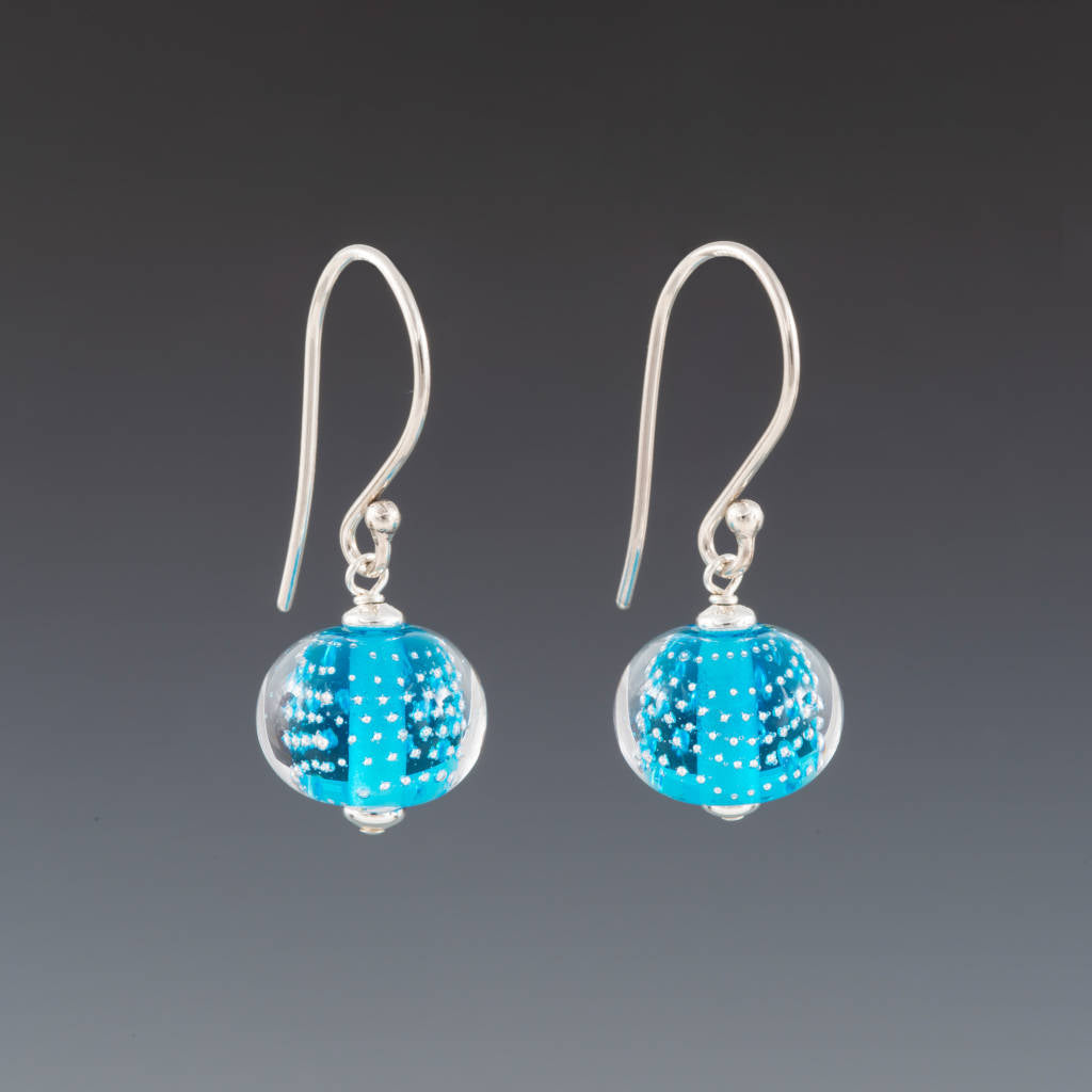 Aquamarine Sparkling Earrings (Ear Wires) by Becky Congdon are handmade glass beads. Each bead is a transparent aquamarine with tiny silver dots then encased in clear. Each bead dangles from simple Bali silver ear wire with tiny silver saucers on either side of the bead.