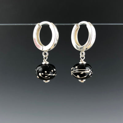 Side view of the Black Constellation Hoop earrings by Becky Congdon. This shows the side view of the modern hoops with the glass beads dangling.