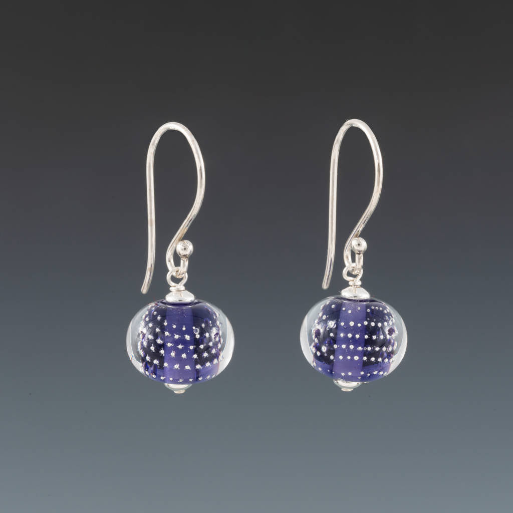 Ink Blue Sparkling Earrings (Ear Wires) by Becky Congdon are handmade glass beads of ink blue (light purple blue) glass with small silver balls encased with clear glass. The beads dangle from silver Bali ear wires with tiny silver saucers on either side of the bead.