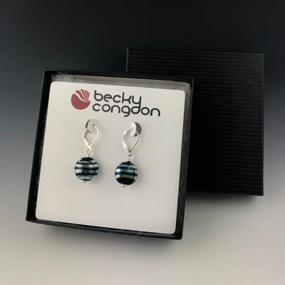 The mirrored striped cobalt blue earrings are on an earring card and displayed with a black pin stripe gift box.